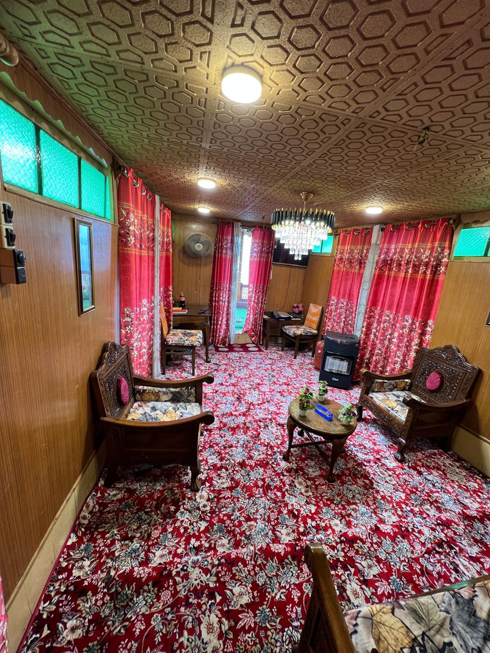 Royal Suite sitting room with carved wooden chairs, chandelier and Kashmiri carpets