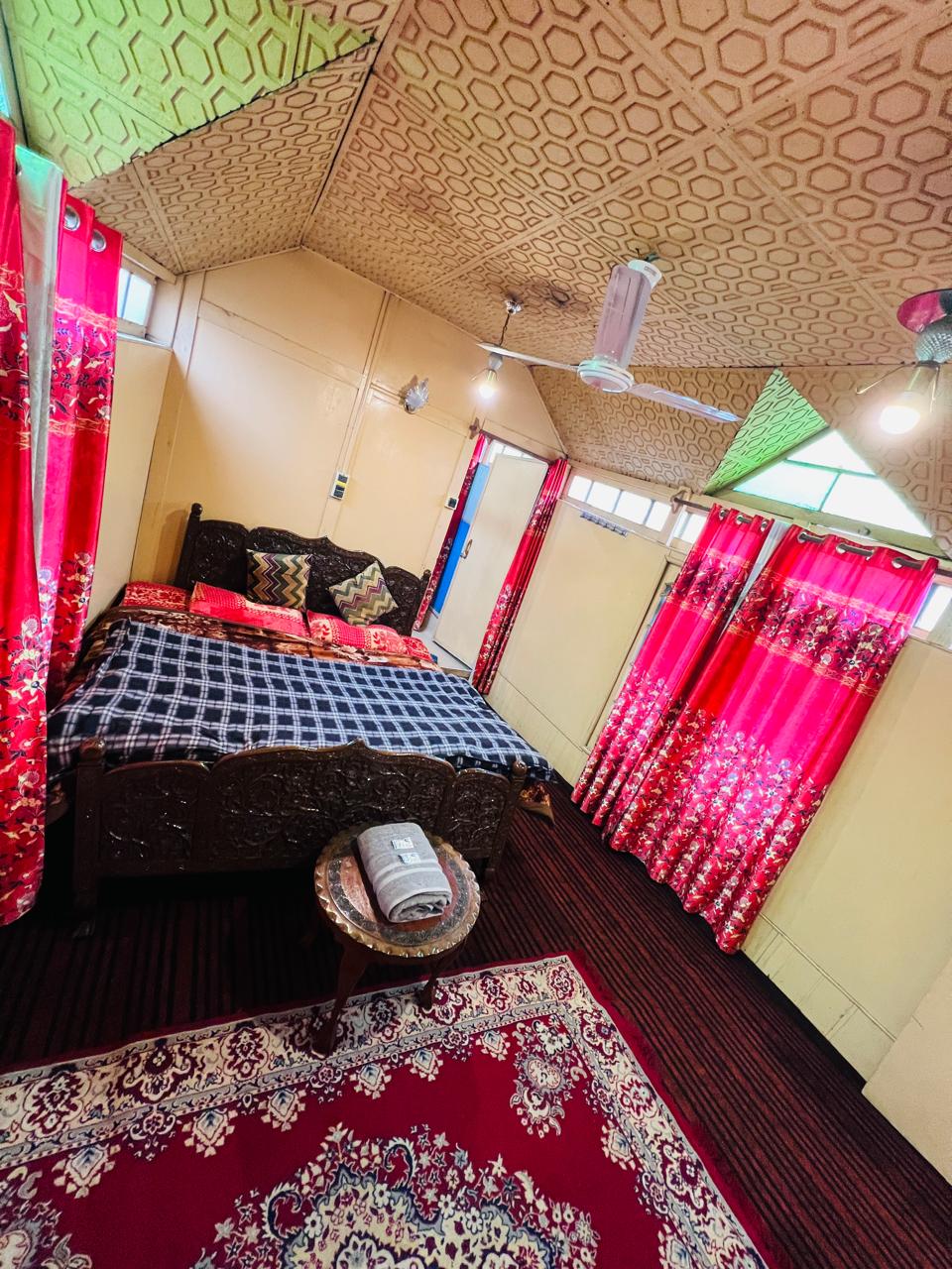 Honeymoon bedroom with carved wooden bed and vibrant Kashmiri carpet