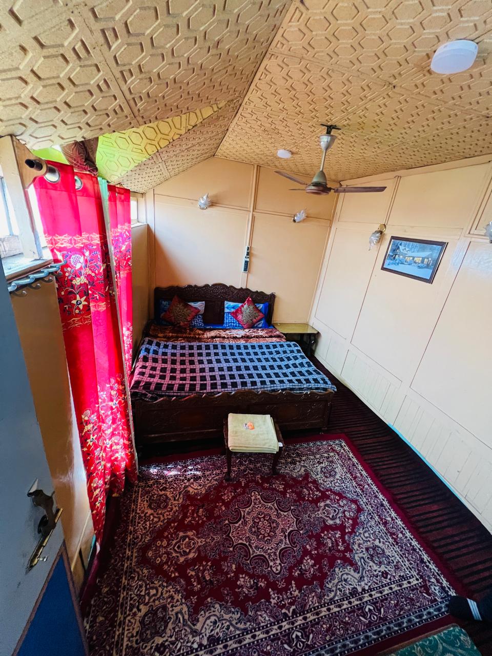 Quiet bedroom with carved wooden bed and Kashmiri carpet